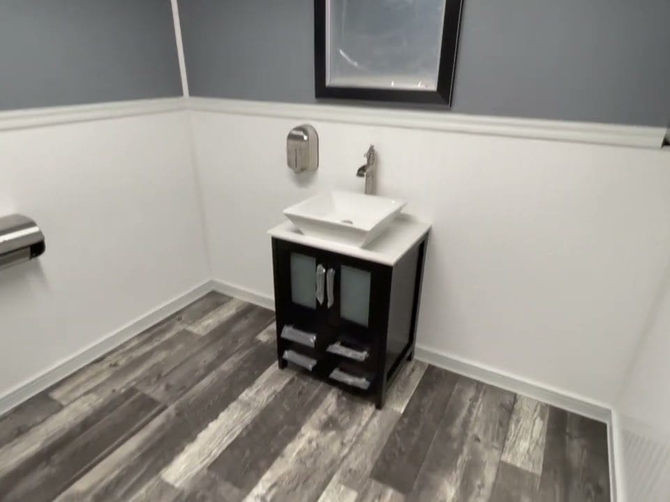 Modern bathroom interior with sink and dark wood vanity in a tiny home trailer bathroom.